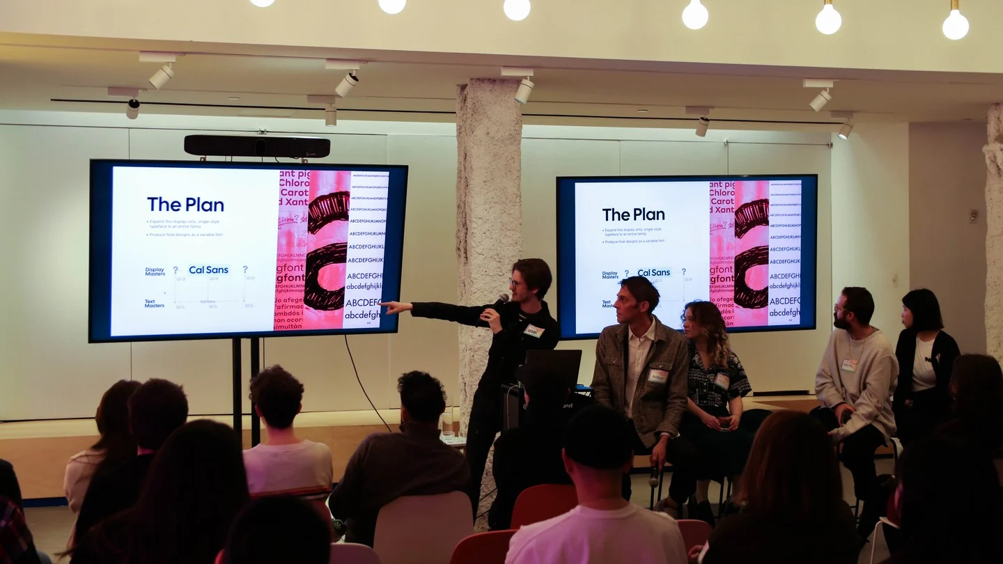 Mark Davis on stage pointing at a slide titled The Plan: expand this display-only, single-style typeface to an entire family